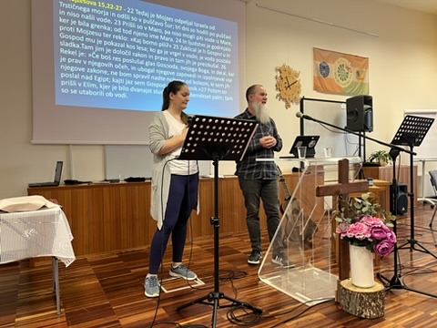 Two people speaking at a church service in Slovenia